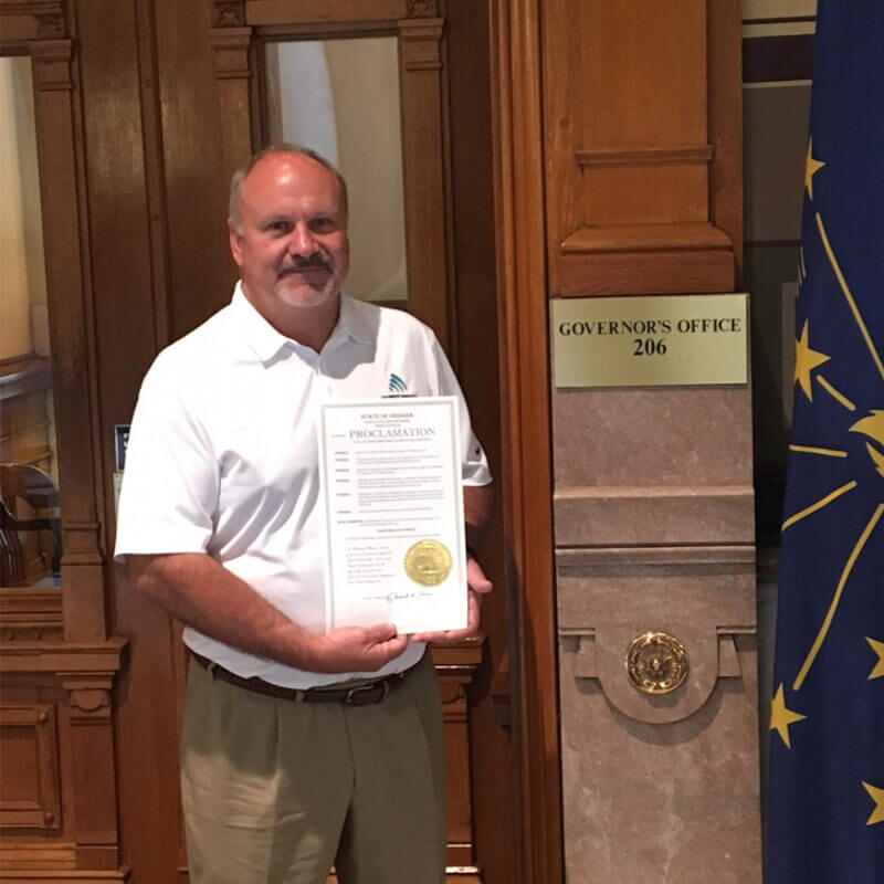 Automatic Supply employee holding up certificate